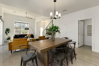 a dining room and living room with a table and chairs at Gorgeous Townhome Steps from the Brewery District! in Fort Collins