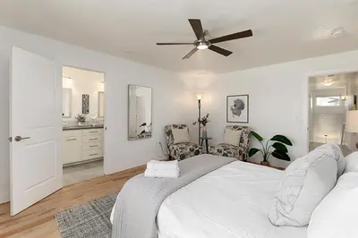 a white bedroom with a bed and a ceiling fan at Gorgeous Townhome Steps from the Brewery District! in Fort Collins