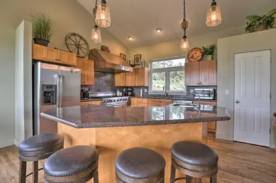 a kitchen with a large island with bar stools at On-Site Hiking Access Mtn-View Conifer Cabin in Conifer