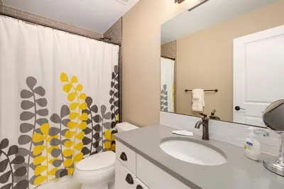 a bathroom with a sink and a toilet and a mirror at Amazing Urban Townhome near Breweries and River! in Fort Collins