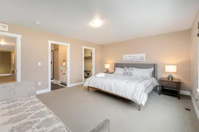 a bedroom with a bed and a table with two lamps at Amazing Urban Townhome near Breweries and River! in Fort Collins