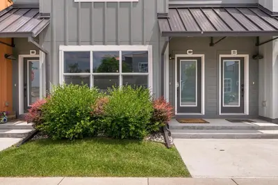 a gray house with a window and a bush at Amazing Urban Townhome near Breweries and River! in Fort Collins