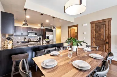 a dining room table with chairs and a kitchen at Spectacular Home near Breweries & River District! in Fort Collins