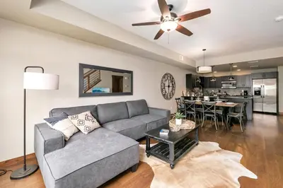 a living room with a couch and a table at Spectacular Home near Breweries & River District! in Fort Collins