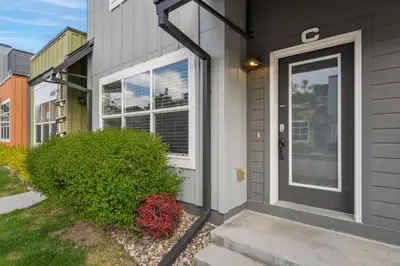 a house with a black door and a bush at Spectacular Home near Breweries & River District! in Fort Collins