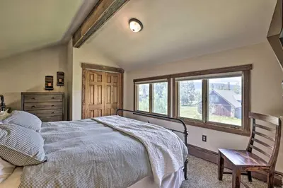 a bedroom with a bed and a chair and a window at 3-Story Home with Balcony about 6 Mi to Winter Park! in Fraser