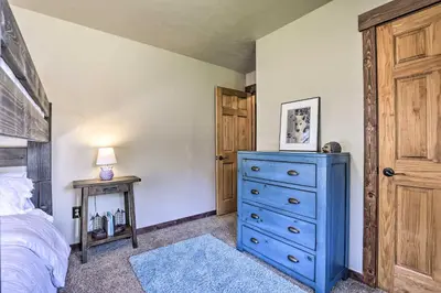 a bedroom with a blue dresser and a bed at 3-Story Home with Balcony about 6 Mi to Winter Park! in Fraser