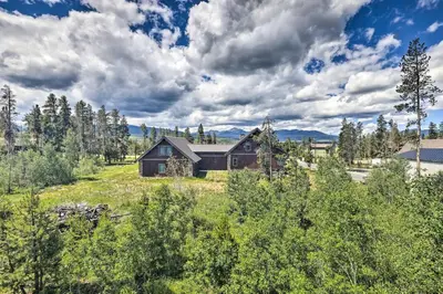 a house in the middle of a field with trees at 3-Story Home with Balcony about 6 Mi to Winter Park! in Fraser