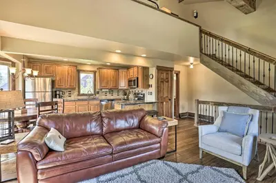 a living room with a leather couch and a chair at 3-Story Home with Balcony about 6 Mi to Winter Park! in Fraser
