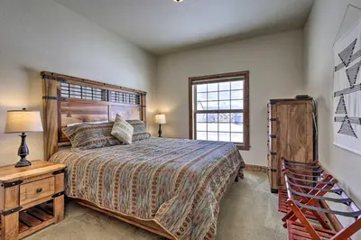 a bedroom with a large bed and a window at Luxe Rocky Mtn Retreat with Hot Tub - By Winter Park in Tabernash