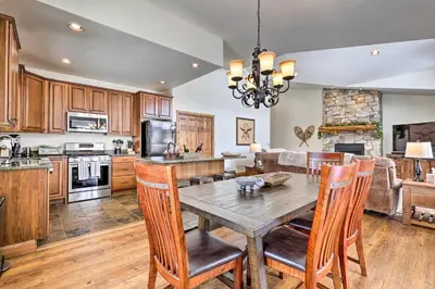 a kitchen and dining room with a wooden table and chairs at Luxe Rocky Mtn Retreat with Hot Tub - By Winter Park in Tabernash