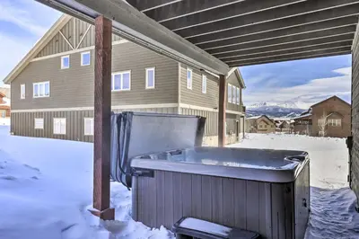 a hot tub in the snow in front of a house at Luxe Rocky Mtn Retreat with Hot Tub - By Winter Park in Tabernash