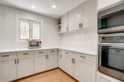 a white kitchen with white cabinets and a window at Luxury Keystone Cabin with Hot Tub, 1 Mi to Lifts! in Keystone