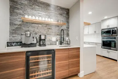 a kitchen with white cabinets and a brick wall at Luxury Keystone Cabin with Hot Tub, 1 Mi to Lifts! in Keystone