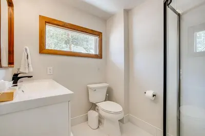 a bathroom with a toilet and a sink and a window at Luxury Keystone Cabin with Hot Tub, 1 Mi to Lifts! in Keystone