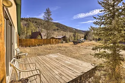 a wooden deck with two chairs on a house at Luxury Keystone Cabin with Hot Tub, 1 Mi to Lifts! in Keystone
