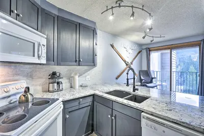 a kitchen with a sink and a microwave at Cozy Ski-InandOut Winter Park Studio with Hot Tubs! in Winter Park