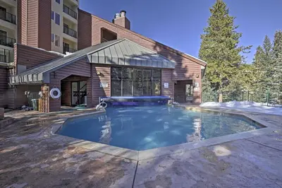 a swimming pool in front of a building at Cozy Ski-InandOut Winter Park Studio with Hot Tubs! in Winter Park