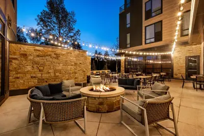 a patio with tables and chairs and a fire pit at Hotel Indigo - Silverthorne by IHG in Silverthorne