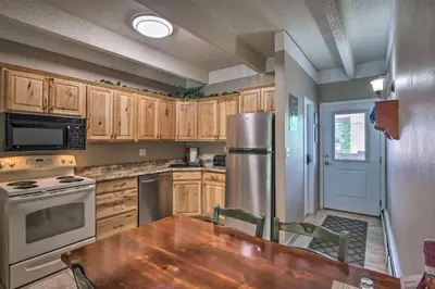 a kitchen with a wooden table and a stainless steel refrigerator at Frisco Condo 2 Blocks to Main St Year-Round Fun! in Frisco