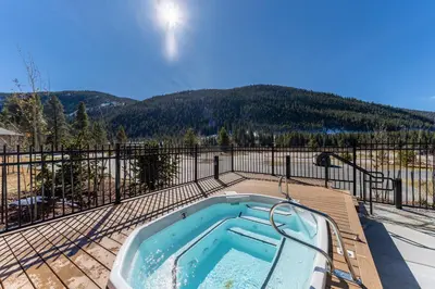 a hot tub on a deck with a fence at Clearwater Lofts 107 Building 3 in Keystone