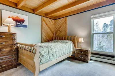a bedroom with a bed and a dresser and a window at F201 Treehouse condo in Silverthorne