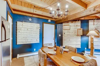 a dining room with blue walls and a wooden table and chairs at F201 Treehouse condo in Silverthorne
