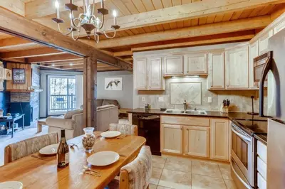 a kitchen with a wooden table and a dining room at F201 Treehouse condo in Silverthorne