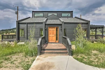 a tiny house with a wooden door and stairs at Evergreen Mountain Duplex with Trail Access! in Idaho Springs