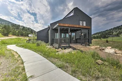 a black house on a hill with a sidewalk at Evergreen Mountain Duplex with Trail Access! in Idaho Springs