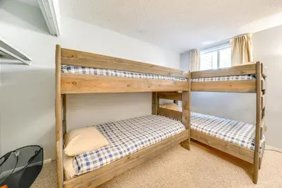 two bunk beds in a room with a window at Warm Fraser Townhome with Community Amenities! in Fraser