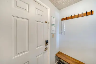a door in a hallway with a bench next to it at Warm Fraser Townhome with Community Amenities! in Fraser