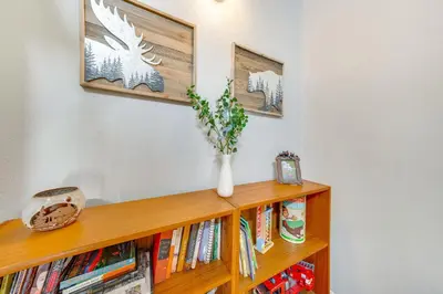 a book shelf with books and a vase on it at Warm Fraser Townhome with Community Amenities! in Fraser