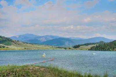 a boat on a lake with mountains in the background at Mountain luxury on Lake Dillon, close to all the best ski resorts in Colorado! in Dillon