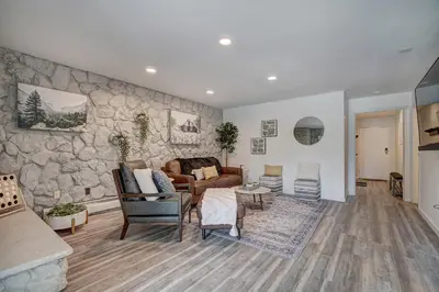 a living room with a stone wall at Mountain luxury on Lake Dillon, close to all the best ski resorts in Colorado! in Dillon