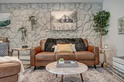 a living room with a couch and a stone wall at Mountain luxury on Lake Dillon, close to all the best ski resorts in Colorado! in Dillon