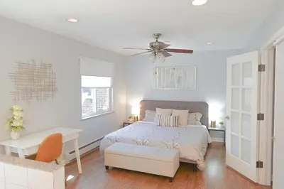 a bedroom with a bed and a table and a ceiling fan at Family-Friendly Retreat 30-Night Minimal in Denver