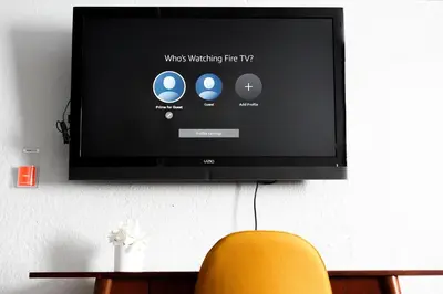 a television hanging on a wall with a yellow chair at Family-Friendly Retreat 30-Night Minimal in Denver
