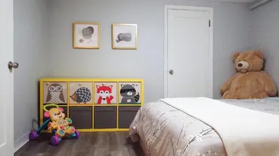 a teddy bear sitting next to a bed in a bedroom at Family-Friendly Retreat 30-Night Minimal in Denver