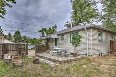 a house with a wooden deck with a table and a tree at Relaxing Golden Getaway with Grill Less Than 1 Mi to Town! in Golden