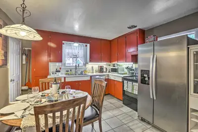 a kitchen with a table and a stainless steel refrigerator at Relaxing Golden Getaway with Grill Less Than 1 Mi to Town! in Golden