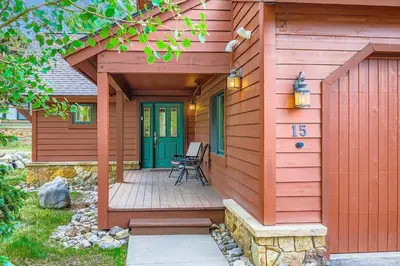 a house with a wooden porch with a bench on it at Highland Greens Oak Retreat townhouse in Breckenridge