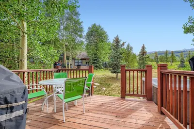 a wooden deck with a table and chairs on it at Highland Greens Oak Retreat townhouse in Breckenridge