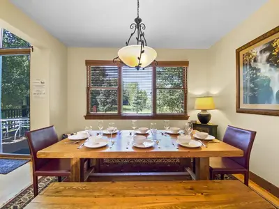 a dining room with a table and chairs and a chandelier at Highland Greens Oak Retreat townhouse in Breckenridge