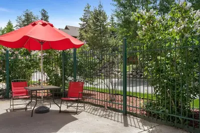 a table and chairs with a red umbrella next to a fence at Gateway Mountain Lodge 5029 - Keystone in Keystone