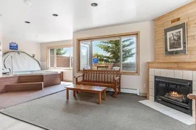 a living room with a bench and a fireplace at Watch Hill #524 - Wildernest in Silverthorne