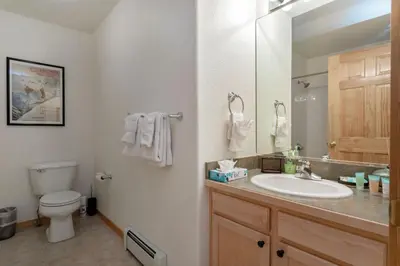 a bathroom with a sink and a toilet and a mirror at Watch Hill #524 - Wildernest in Silverthorne