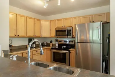 a kitchen with wooden cabinets and a stainless steel refrigerator at Watch Hill #524 - Wildernest in Silverthorne