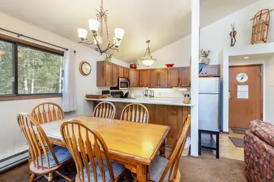 a kitchen and dining room with a wooden table and chairs at 1196 Flying Dutchman condo in Keystone