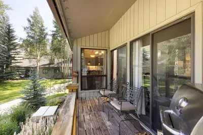 a screened porch with two chairs and a table at 1196 Flying Dutchman condo in Keystone